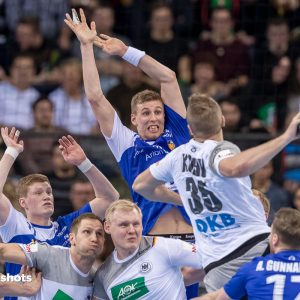 Julius Kuehn beim Wurf – Gedraenge in der Abwehr der Islaender Julius Kuehn beim Wurf - Gedraenge in der Abwehr der Islaender